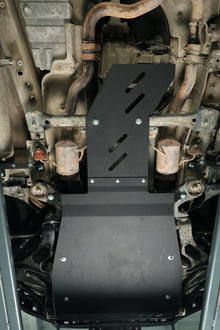 Close-up of a vehicle's undercarriage with protective skid plates.